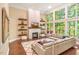 Bright living room with a cozy fireplace and a large window overlooking the outdoors at 412 Bowen Rd, Rougemont, NC 27572