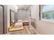 Modern bathroom features a double sink vanity, tub with tiled walls, and a window with natural light at 4501 Rockwood Dr, Raleigh, NC 27612