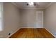Neutral bedroom features hardwood flooring, ceiling fan and a door at 4501 Rockwood Dr, Raleigh, NC 27612