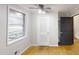 Bright bedroom features hardwood flooring, ceiling fan, two windows and a closet at 4501 Rockwood Dr, Raleigh, NC 27612