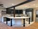 Modern kitchen with stainless steel appliances, dark cabinets, and a large island at 4501 Rockwood Dr, Raleigh, NC 27612
