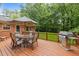 Outdoor wooden deck featuring patio furniture, a grill, and a beautiful, green backyard at 4505 Wood Valley Dr, Raleigh, NC 27613