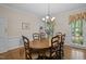 Elegant dining room featuring hardwood floors, wainscoting, and a classic chandelier for memorable dining experience at 4505 Wood Valley Dr, Raleigh, NC 27613