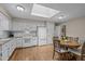 Open kitchen and dining area features white appliances and a skylight at 4505 Wood Valley Dr, Raleigh, NC 27613