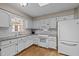 Well-lit kitchen features white cabinets, stainless appliances, granite countertops, and hardwood floors at 4505 Wood Valley Dr, Raleigh, NC 27613