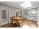 Bright eat-in kitchen featuring wood floors, a skylight, and a charming breakfast area with a table at 4505 Wood Valley Dr, Raleigh, NC 27613