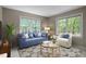 Cozy living room with natural light, a blue couch, and stylish decor at 4505 Wood Valley Dr, Raleigh, NC 27613