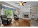 Inviting living room with a brick fireplace, built-in shelves, and a large window for natural light at 4505 Wood Valley Dr, Raleigh, NC 27613