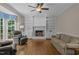Inviting living room with a brick fireplace, built-in shelves, and a large window for natural light at 4505 Wood Valley Dr, Raleigh, NC 27613