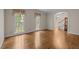 Spacious living room with hardwood floors and views to the staircase with large windows that bring in natural light at 4505 Wood Valley Dr, Raleigh, NC 27613
