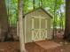 Wooden storage shed is nestled between mature trees at 4505 Wood Valley Dr, Raleigh, NC 27613