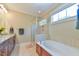 Bathroom featuring a soaking tub and separate shower with light tiled walls at 457 S Greensboro St, Carrboro, NC 27510