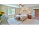 Bright bedroom featuring a large window, ceiling fan, and comfortable seating at 457 S Greensboro St, Carrboro, NC 27510