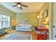 Comfortable bedroom featuring hardwood floors, a ceiling fan, and a large window for plenty of natural light at 457 S Greensboro St, Carrboro, NC 27510