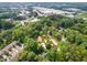 Stunning aerial view of a community surrounded by lush green trees, nearby shopping and commercial buildings at 4832 Brookhaven Dr, Raleigh, NC 27612