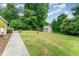 Private backyard featuring lush greenery, mature trees, well-maintained lawn and a charming storage shed at 4832 Brookhaven Dr, Raleigh, NC 27612