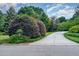 Extended driveway leading to a well-manicured yard with mature bushes and trees at 4832 Brookhaven Dr, Raleigh, NC 27612