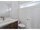View of the bathroom with modern fixtures, toilet and sink with white countertop, and a horizontal window at 512 Gordon St # 1006, Durham, NC 27701