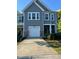 Charming townhome featuring stone accents, a one-car garage, and a welcoming front entrance at 5122 Jessip St, Morrisville, NC 27560