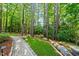 Lush backyard featuring a stone pathway, manicured lawn and wooded area around the perimeter at 5217 Roswellcrest Ct, Apex, NC 27539