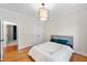 A simple bedroom space with an overhead light, bed and hardwood floors at 5217 Roswellcrest Ct, Apex, NC 27539
