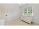 Bright bedroom featuring a white baby crib, neutral walls, plush carpet, and a window at 5217 Roswellcrest Ct, Apex, NC 27539