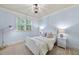 A cozy bedroom with a full bed, two bedside tables, a floor lamp and a window with a tree view at 5217 Roswellcrest Ct, Apex, NC 27539