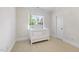 Bright bedroom features a white baby crib, neutral walls, plush carpet, and a window at 5217 Roswellcrest Ct, Apex, NC 27539
