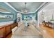 Elegant dining room featuring wainscoting, statement lighting, and a large wood table at 5217 Roswellcrest Ct, Apex, NC 27539