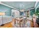 Bright dining room with modern chandelier, light wood floors, and an open doorway to living spaces at 5217 Roswellcrest Ct, Apex, NC 27539