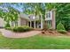 Charming brick home featuring a manicured front yard, garden, and a welcoming brick walkway at 5217 Roswellcrest Ct, Apex, NC 27539