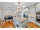 Open-concept kitchen with island, stainless appliances, hardwood floors, and an adjacent dining area at 5217 Roswellcrest Ct, Apex, NC 27539
