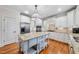 Spacious kitchen boasts a central island, stainless steel appliances, and pristine white cabinetry at 5217 Roswellcrest Ct, Apex, NC 27539