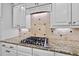A modern kitchen featuring a Viking gas range, granite counters and stylish backsplash at 5217 Roswellcrest Ct, Apex, NC 27539