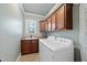 Well-organized laundry room with wood cabinets, a sink, and modern washer and dryer at 5217 Roswellcrest Ct, Apex, NC 27539