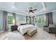 Relaxing main bedroom with tray ceiling, neutral color scheme, and large windows showcasing natural light at 5217 Roswellcrest Ct, Apex, NC 27539
