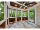 Relaxing screened-in porch featuring a fan, wood paneled walls, and a view of the surrounding trees at 5217 Roswellcrest Ct, Apex, NC 27539