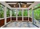 Relaxing screened-in porch featuring a fan, wood paneled walls, and a view of the surrounding trees at 5217 Roswellcrest Ct, Apex, NC 27539