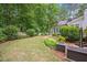Lush backyard featuring mature trees and landscaping with a charming white picket fence at 5241 Mill Dam Rd, Wake Forest, NC 27587