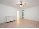 Bright bedroom showcasing light hardwood floors, a white dresser, and a door leading outside at 5241 Mill Dam Rd, Wake Forest, NC 27587