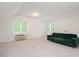 Spacious bonus room with a comfortable green sofa and natural light at 5241 Mill Dam Rd, Wake Forest, NC 27587