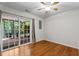 Bedroom with hardwood floors, fan, and glass sliding doors to the backyard at 5310 Echo Ridge Rd, Raleigh, NC 27612