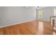 Large, naturally lit room featuring hardwood floors, neutral walls, and a ceiling fan at 5310 Echo Ridge Rd, Raleigh, NC 27612
