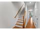 A well-lit staircase with wooden rails and white risers leads to the upper floor at 5310 Echo Ridge Rd, Raleigh, NC 27612