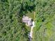 Aerial view of a private residence nestled in a lush forest with manicured lawn and long driveway at 59 Mill Rd, Pittsboro, NC 27312
