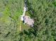 Overhead view of wooded home with long driveway and manicured lawn surrounded by dense trees at 59 Mill Rd, Pittsboro, NC 27312