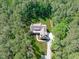 Aerial view of secluded modern farmhouse surrounded by vibrant green trees and impeccable landscaping at 59 Mill Rd, Pittsboro, NC 27312