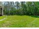 Lush green backyard with mature trees offers space for outdoor activities at 59 Mill Rd, Pittsboro, NC 27312