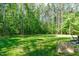 Picturesque backyard with lush green grass and mature trees offers privacy and space at 59 Mill Rd, Pittsboro, NC 27312