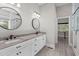 Bright bathroom with double sinks, granite counters, modern fixtures and a large round mirror at 59 Mill Rd, Pittsboro, NC 27312